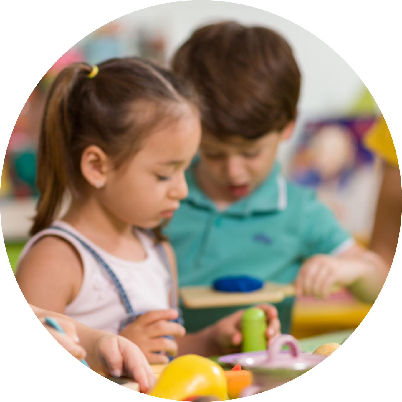 Lovely children laying on multicolor canopy in circle. Team building game for daycare children in colorful t-shirts. Top view kids on wooden floor at Angelic Treasures Christian Daycare